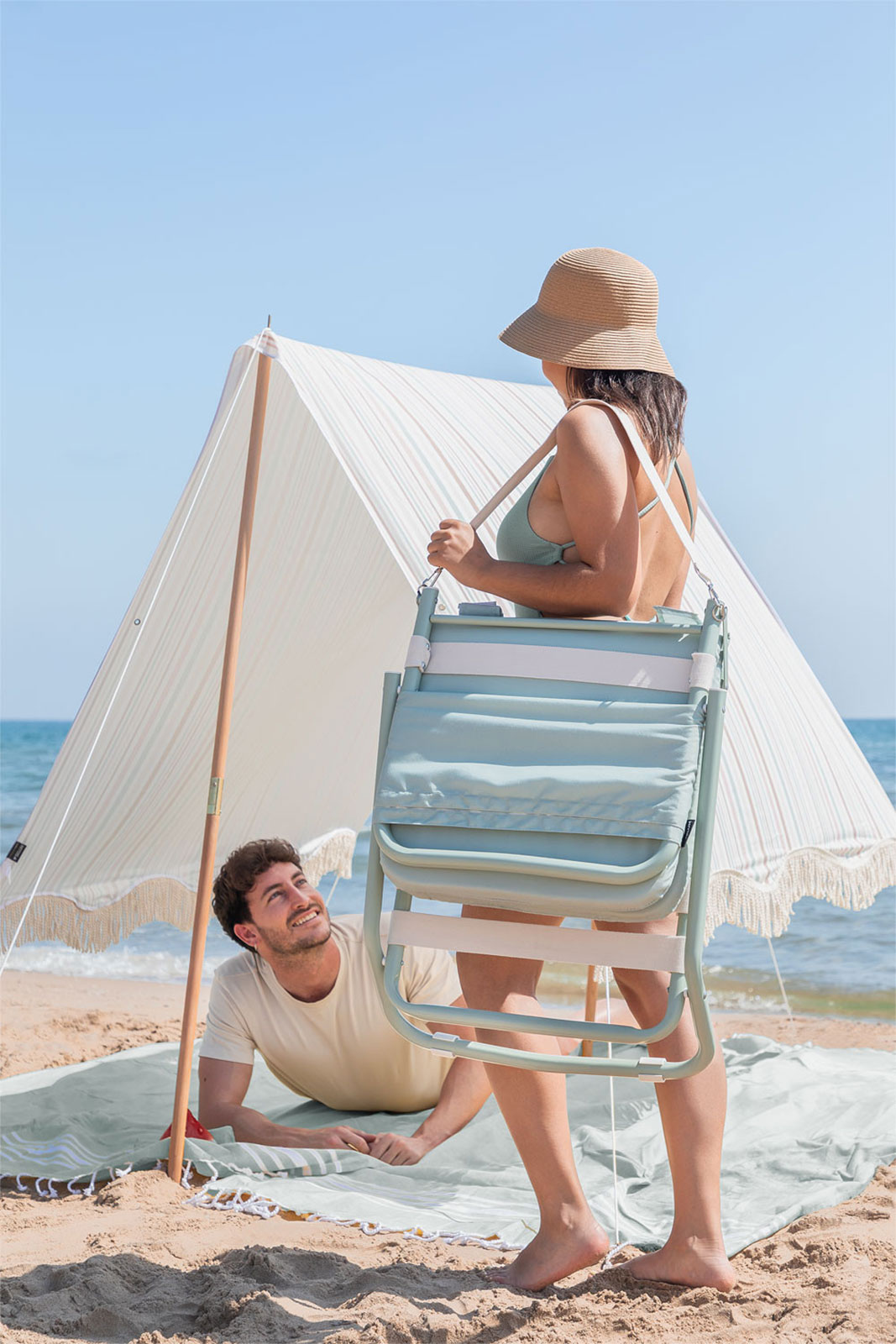 mujer transportando una silla de playa plegable