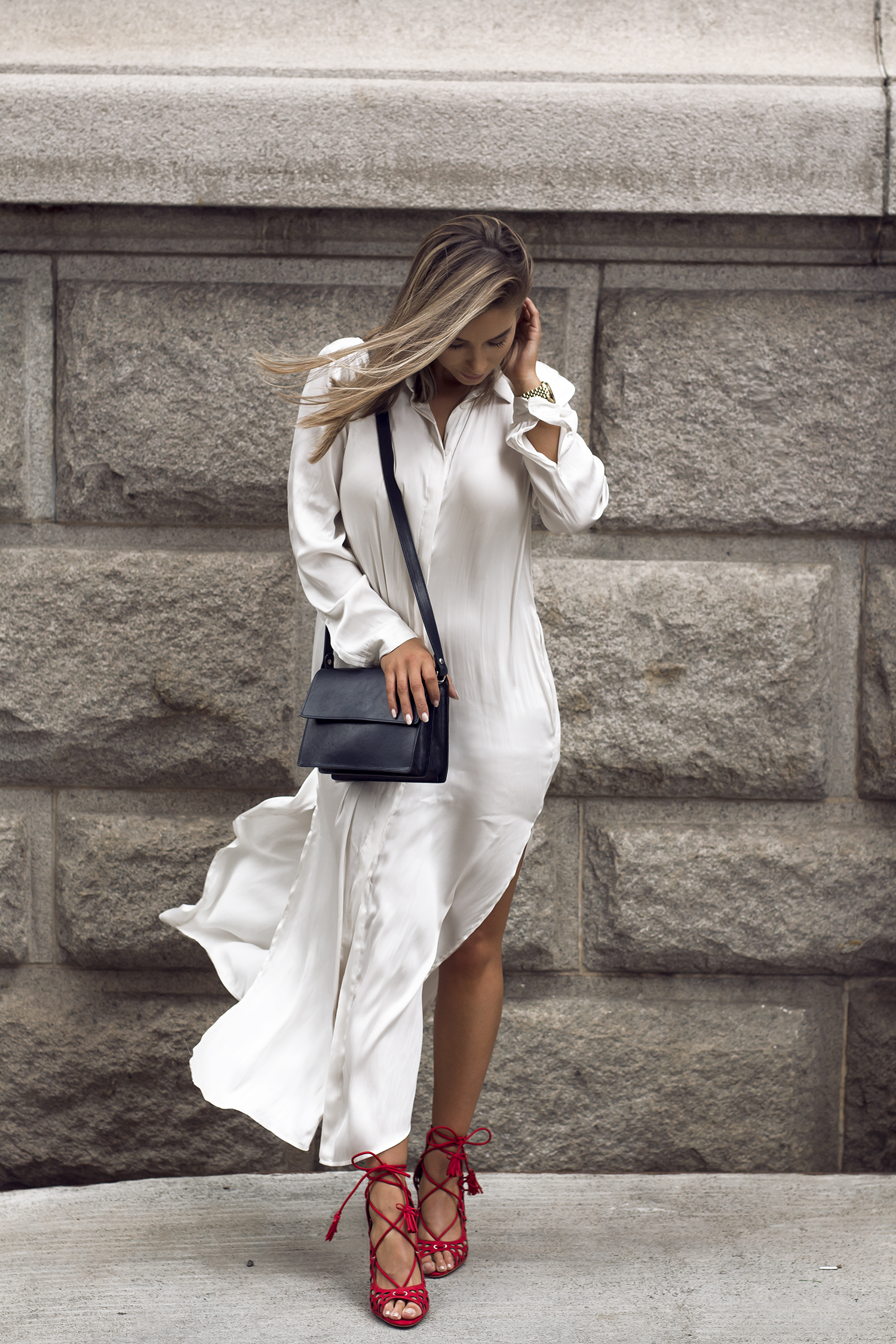 Outfit con vestido camisero de seda en color blanco con aberturas y zapatos de tacon rojos