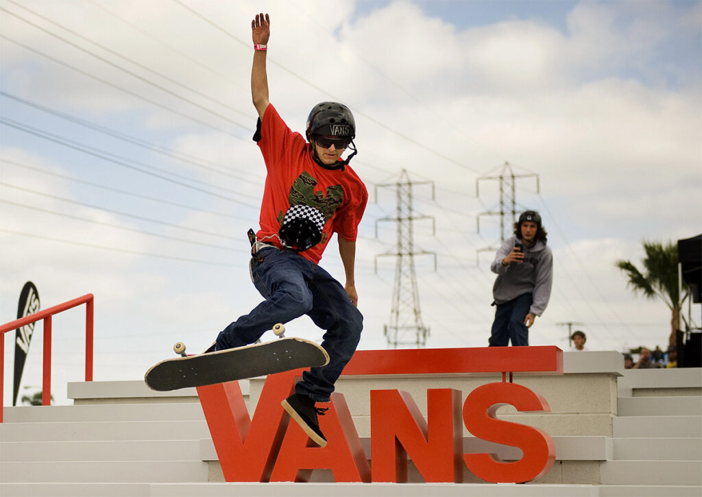 skatersaltando sobre el logo de vans en rojo